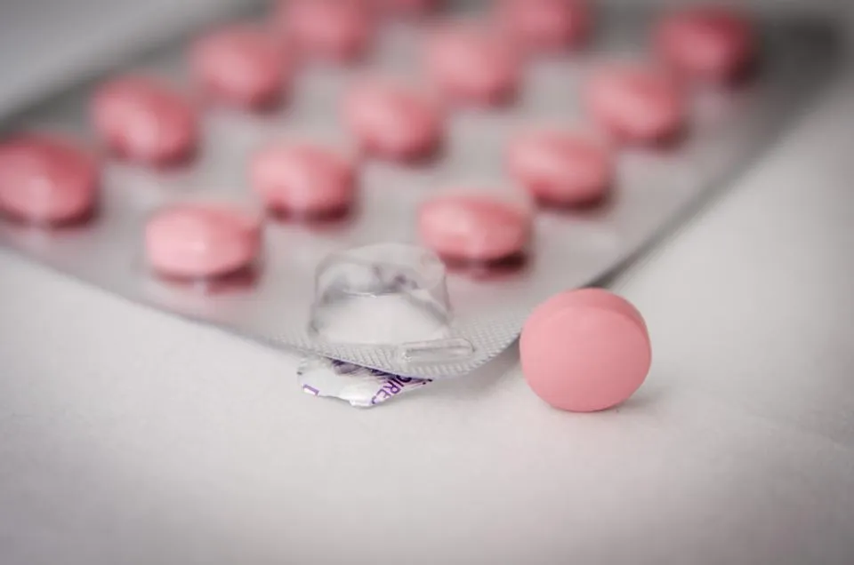 Blister pack of pink tablets with one tablet pressed out
